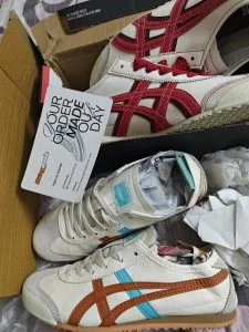 Two pairs of retro runners in cream, red and tan, unboxed by the customer