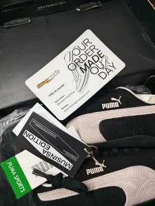 Pale pink and black suede trainers in their box, tags still attached