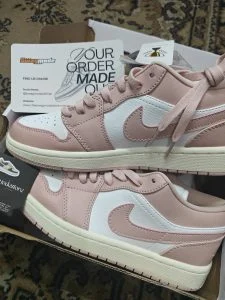 A pair of dusty pink and white low-tops unboxed by the customer