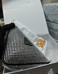 A crystal-set triangular clutch bag in its box, photographed on arrival