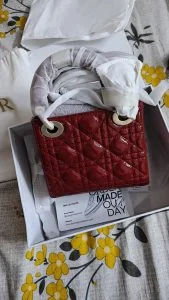 A red quilted mini handbag with its dust bag, as delivered