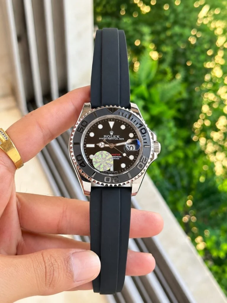 Automatic watch with a black dial, held in hand