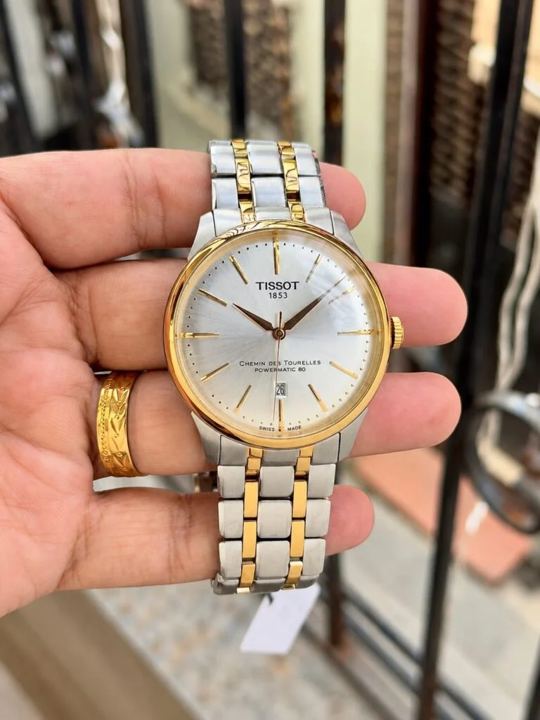 Two-tone automatic dress watch with a silver sunburst dial and gold-tone markers