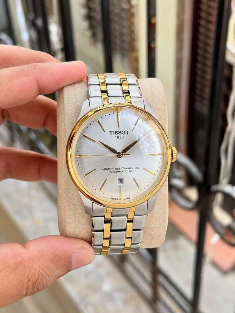 Two-tone automatic dress watch with a silver sunburst dial and gold-tone markers