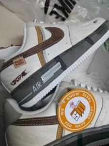A cream low-top sneaker with a brown suede swoosh and the Swag Mode hang tag, still in its delivery box