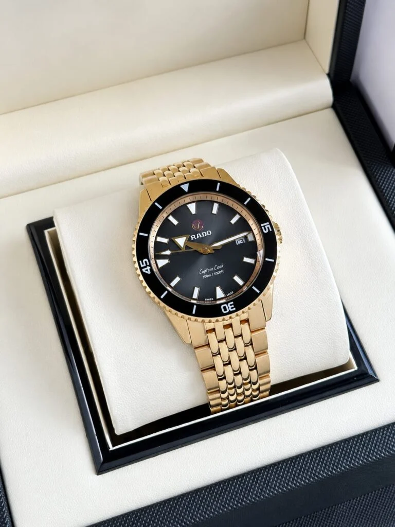 Gold-tone 42mm automatic dive watch with a black dial and black ceramic bezel
