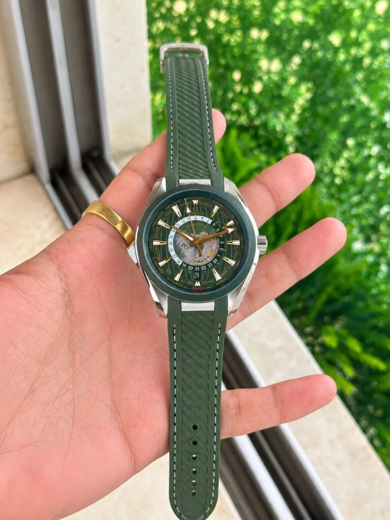World map automatic watch with a green dial, held in the hand